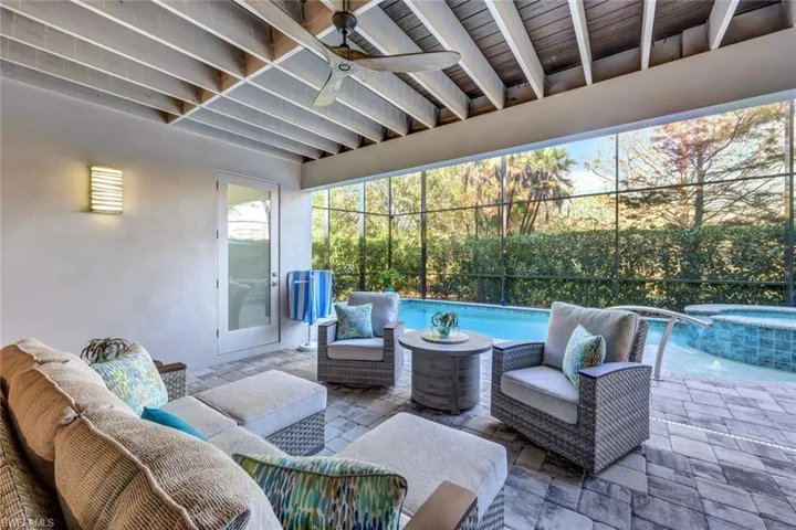 View of patio / terrace featuring ceiling fan, a swimming pool with hot tub, an outdoor living space