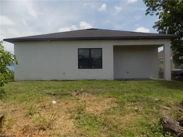 View of side of property featuring stucco siding and a yard