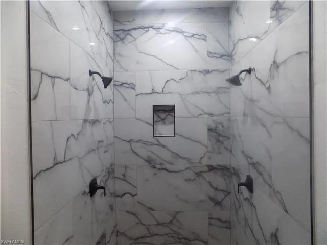 Full bath featuring a marble finish shower