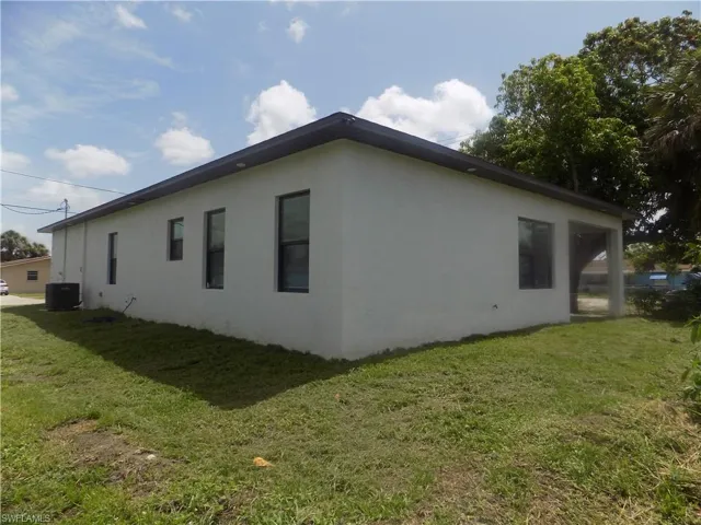 View of side of home featuring stucco siding and a yard