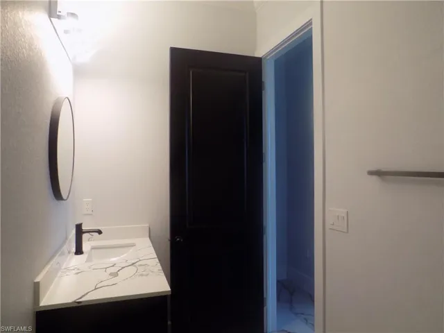 Bathroom featuring vanity and marble finish flooring