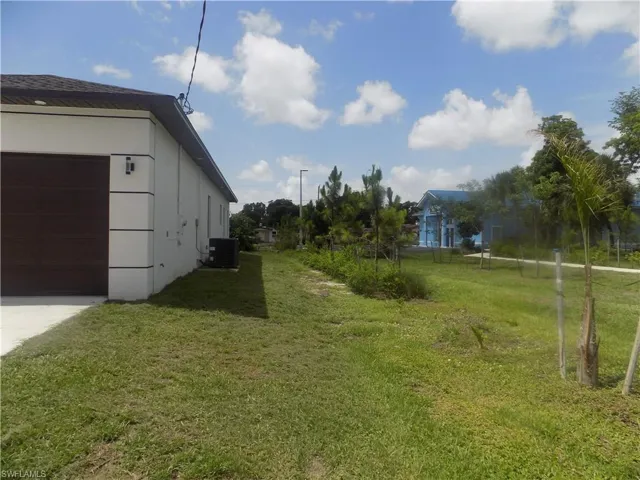 View of grassy yard with a garage