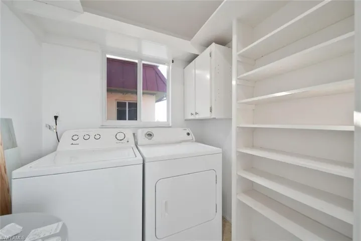 Washroom featuring washer and clothes dryer and cabinet space