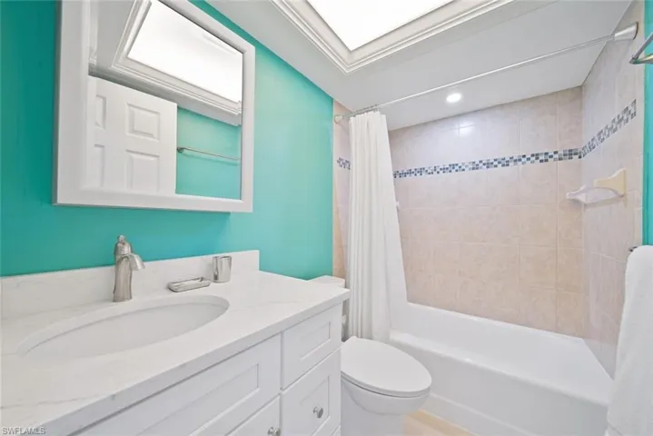 Bathroom with shower / tub combo, vanity, and recessed lighting