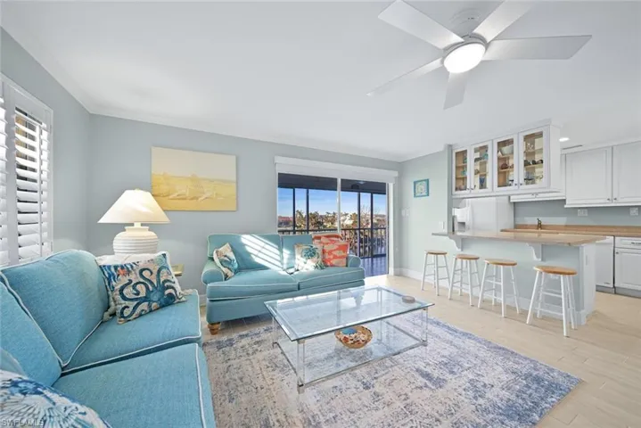 Living room featuring light wood-type flooring, crown molding, and ceiling fan