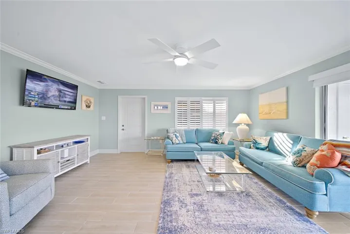 Living area featuring ornamental molding, wood finish floors, and a ceiling fan