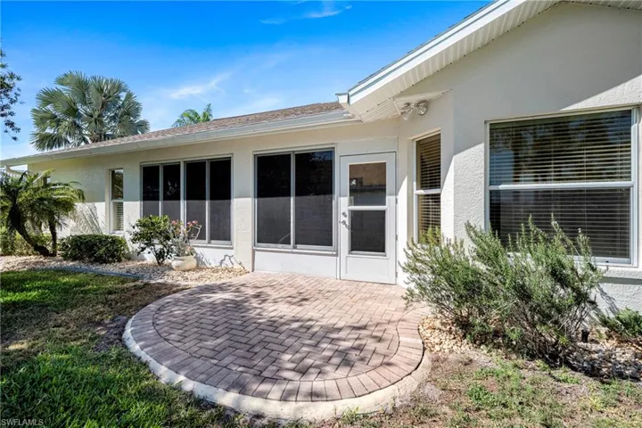 Back of house featuring stucco siding, a patio, and a sunroom