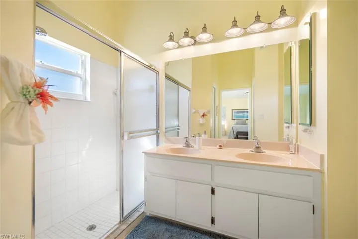 Ensuite bathroom featuring double vanity and a stall shower