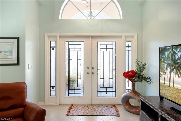 Entryway featuring plenty of natural light, french doors, tile patterned floors, and a high ceiling