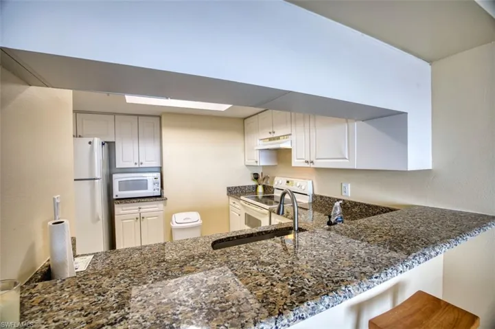 Kitchen with white appliances, granite countertops