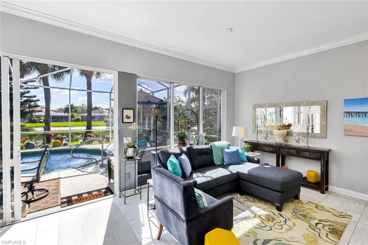 Living space featuring large format tile flooring and crown molding