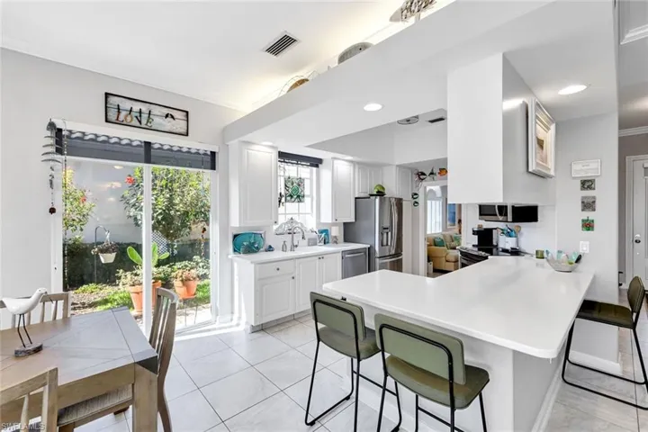 Kitchen with white shaker cabinetry, stainless steel appliances, and white countertops