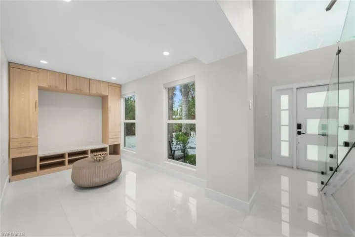 Foyer entrance with light tile patterned flooring and recessed lighting