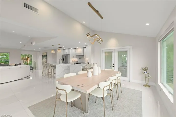 Dining room featuring french doors, vaulted ceiling, recessed lighting, and light tile patterned flooring