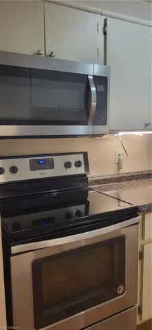 Interior details with white cabinets and stainless steel stove