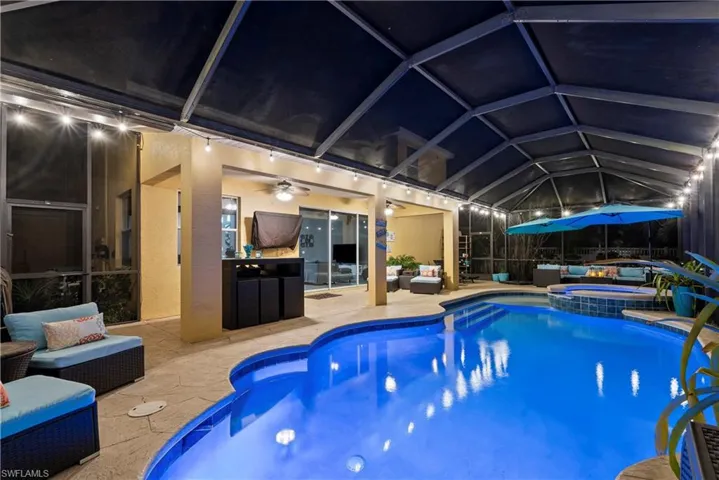 View of swimming pool featuring an in ground hot tub, a lanai, and a patio