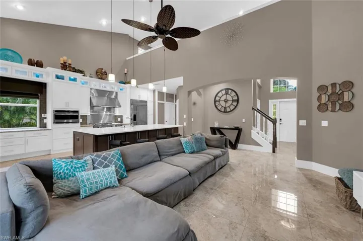 Living room featuring ceiling fan and a towering ceiling