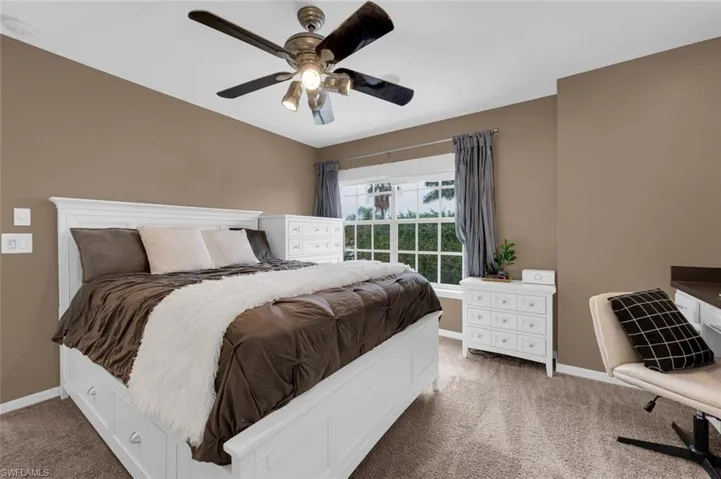 Carpeted bedroom featuring ceiling fan