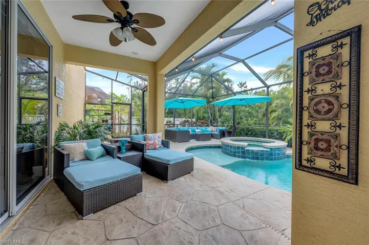 View of pool featuring an in ground hot tub, a lanai, a patio, ceiling fan, and an outdoor hangout area
