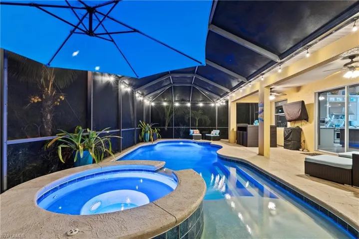 View of pool featuring a lanai, a patio area, ceiling fan, and an in ground hot tub