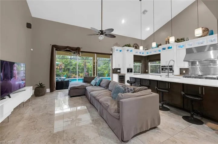 Living room with sink, a towering ceiling, and ceiling fan