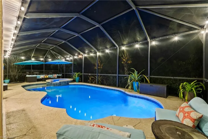 View of pool featuring an in ground hot tub, outdoor lounge area, a patio area, and a lanai