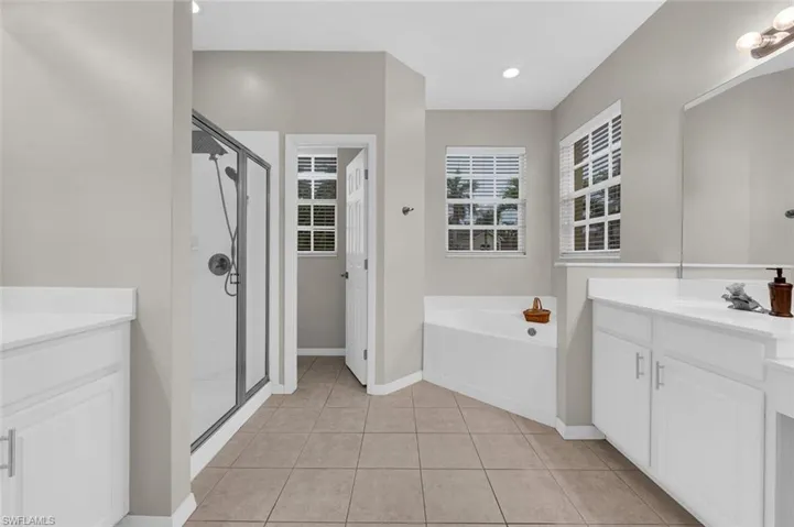 Bathroom featuring vanity, separate shower and tub, and tile patterned flooring