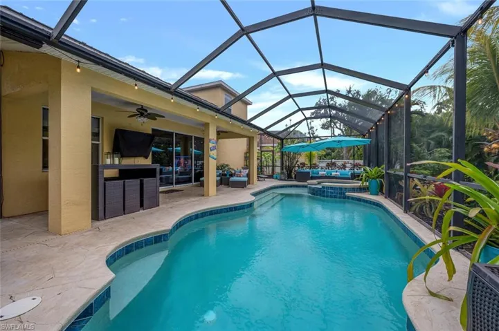 View of pool with an in ground hot tub, a lanai, ceiling fan, a patio area, and an outdoor hangout area