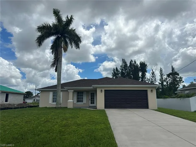 Ranch-style house with stucco siding, driveway, and a garage