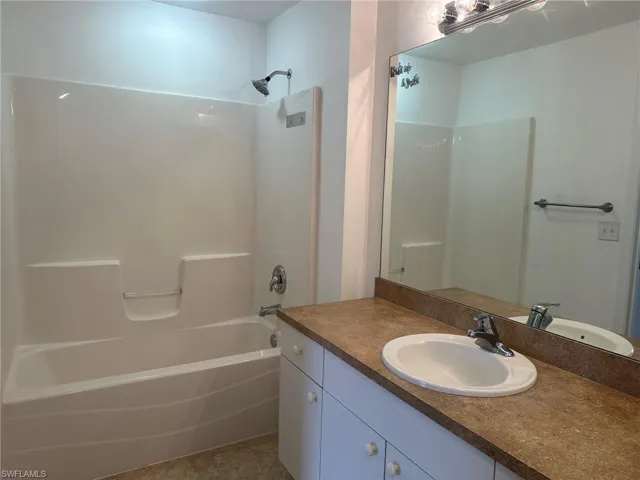 Bathroom featuring shower / bath combination, vanity, and light tile patterned floors