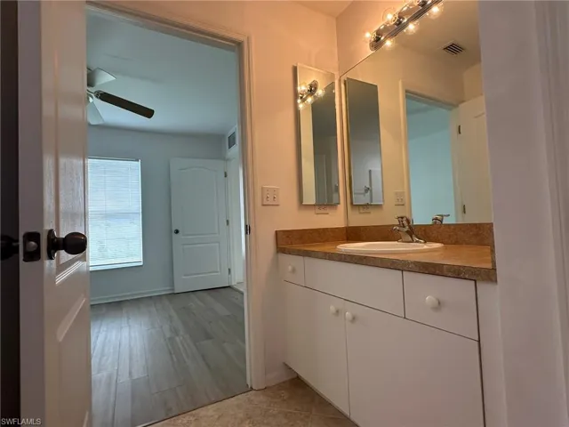 Half bath featuring vanity, light wood-type flooring, and ceiling fan
