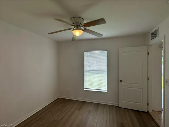 Unfurnished room featuring wood finished floors and plenty of natural light