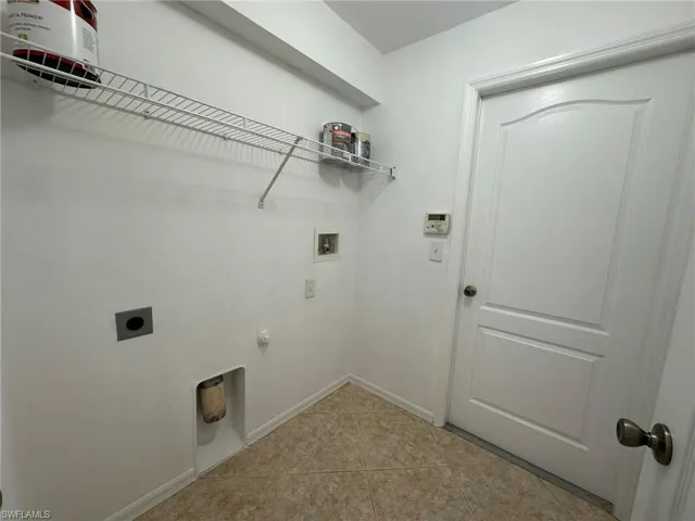Laundry room featuring light tile patterned flooring, hookup for a washing machine, and electric dryer hookup