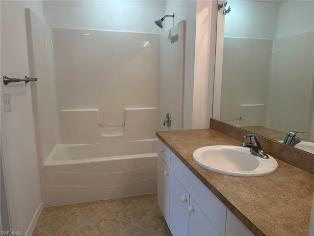 Full bathroom featuring bathing tub / shower combination, vanity, and light tile patterned floors