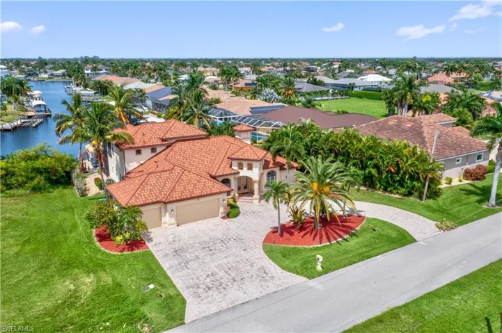 Bird's eye view featuring a water view, 3 car garage and a circular pavered driveway