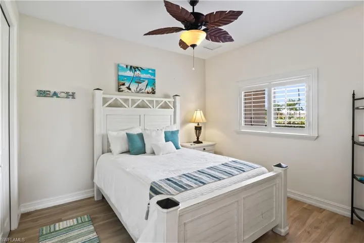 Guest bedroom featuring a closet, ceiling fan, and wood-type flooring