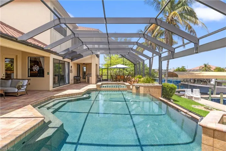 View of pool with 62 X 28 screened enclosure and an in ground hot tub