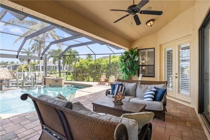 View of patio / terrace featuring an outdoor hangout area, pool water feature, a pool with hot tub, ceiling fan, and a lanai