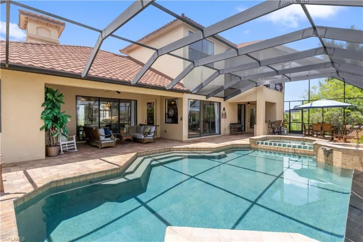 View of pool with an in ground hot tub, an outdoor living space, a patio, and a lanai