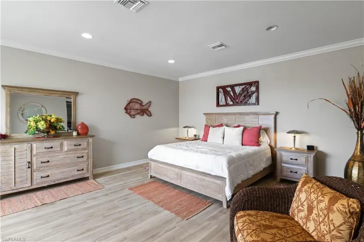2nd floor bedroom with light wood-type flooring and ornamental molding