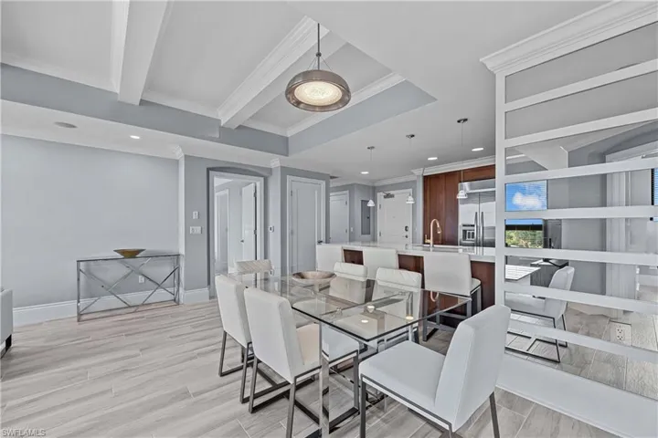 Dining space with light wood-type flooring, sink, and ornamental molding