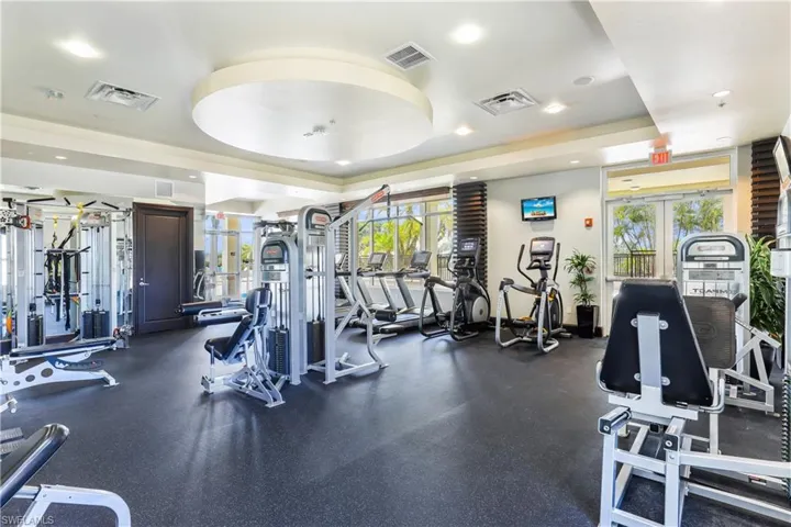 Workout area featuring a tray ceiling and plenty of natural light