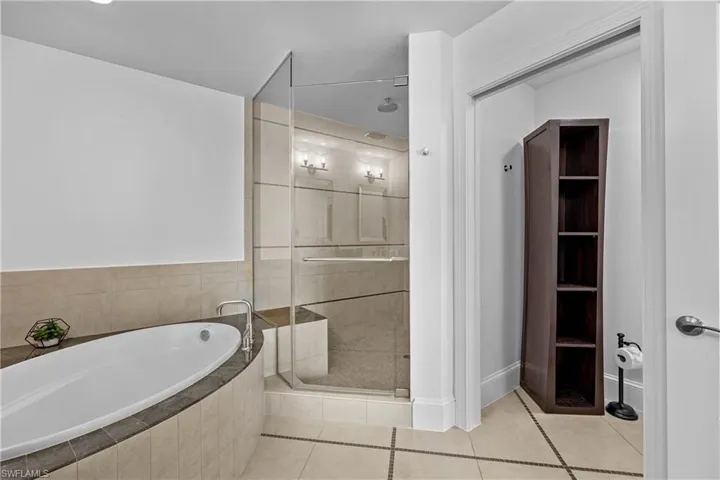 Bathroom featuring plus walk in shower and tile patterned flooring