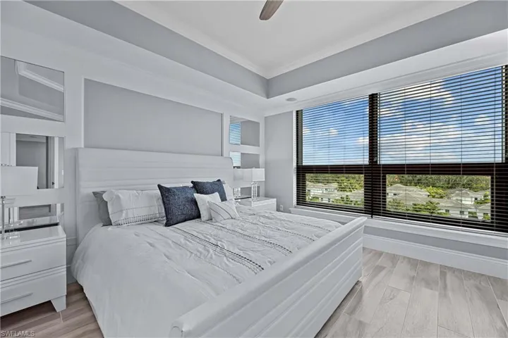 Bedroom featuring light wood-type flooring, ceiling fan, and ornamental molding