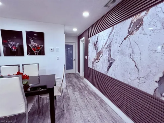 Dining room featuring light wood-style floors, recessed lighting, and an accent wall