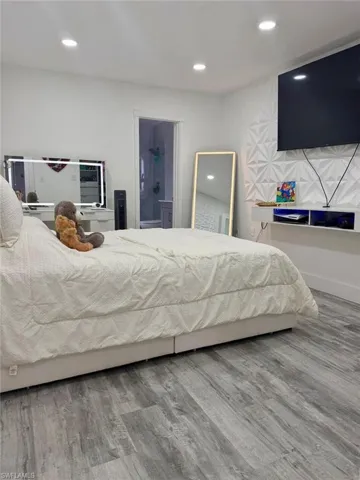 Bedroom featuring light wood-style floors, recessed lighting, and ensuite bathroom