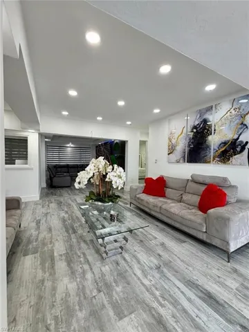 Living room with light wood finished floors and recessed lighting
