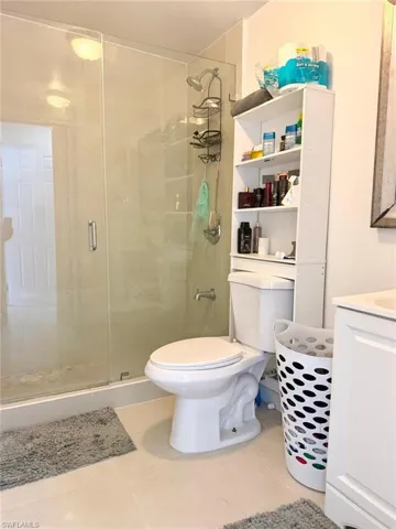 Bathroom with vanity, a shower stall, and light tile patterned floors
