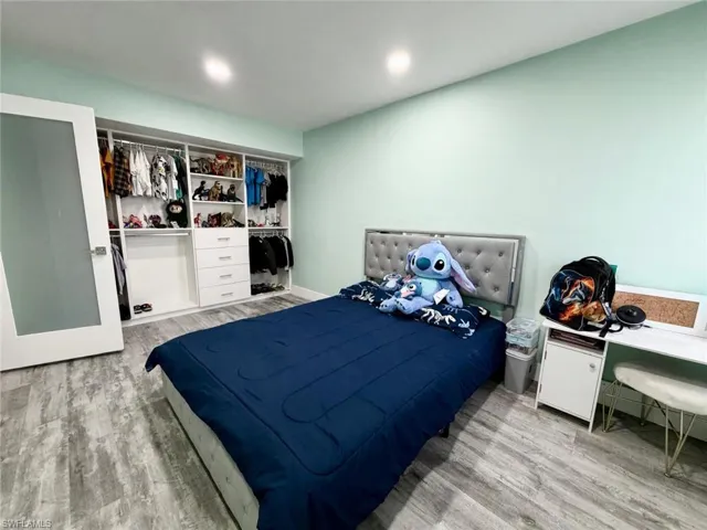 Bedroom with light wood-type flooring, a closet, and recessed lighting