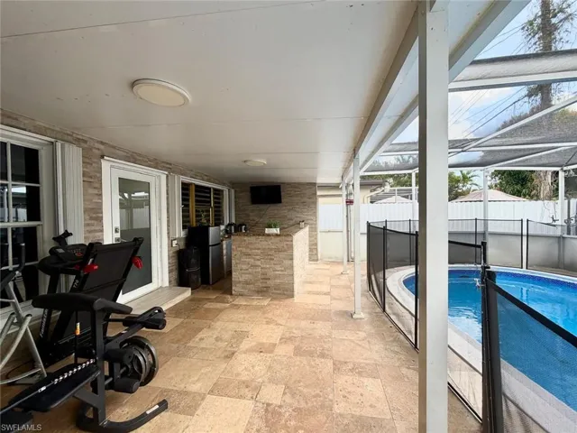 Fenced backyard featuring a patio, glass enclosure, and a sunroom